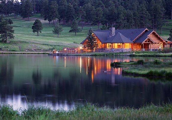 Mountain Lodge in Evergreen Colorado Reflecting in Lake at Dusk. This lodge is part of the public park area.